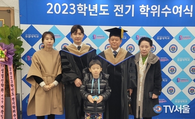 박근주 회장과 박성민 대표이사가 명예박사 학위를 받고 가족들과 기념 촬영.