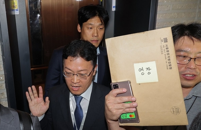 김건희 여사의 의혹들을 수사하는 민중기 특별검사팀이 18일 서울 여의도 국민의힘 중앙당사에 대한 '통일교 집단 입당' 의혹과 관련한 압수수색에 나섰다. 당사에 도착한 특검팀이 영장을 들고 당사에 진입하기 위해 승강기에 오르고 있다. /사진=연합뉴스