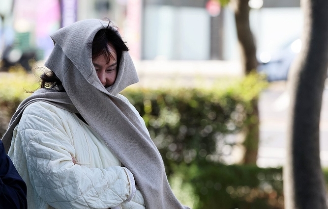  27일 광주 서구 치평동에서 한 시민이 갑작스레 찾아온 추위에 목도리와 패딩 차림을 하고 걷고 있다. 