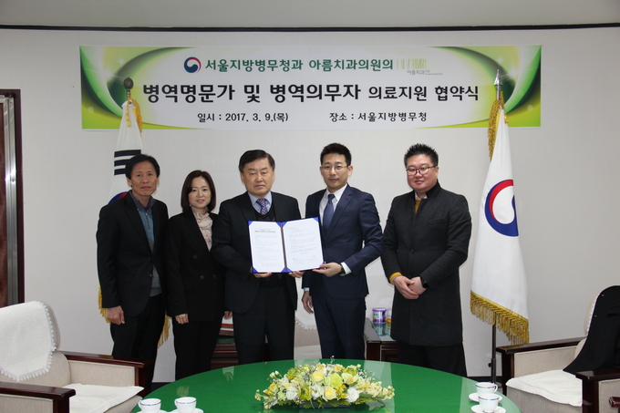 황평연 서울병무청장과 김종배 아름치과 대표원장 등이 협약서에 서명한 후 기념촬영을 하고 있다. 